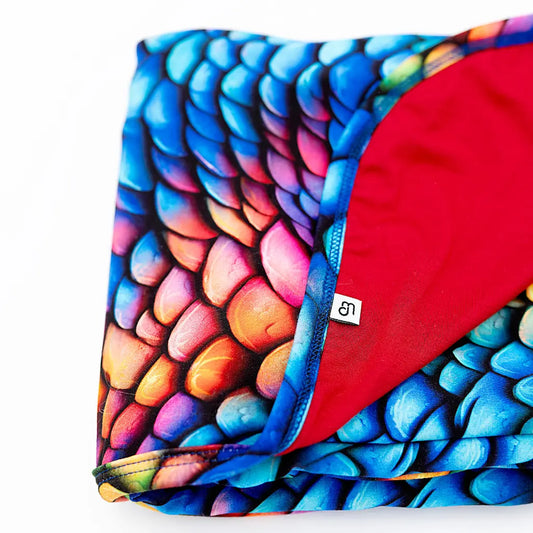 Colorful dragon scale patterned fabric with a red interior on a white background