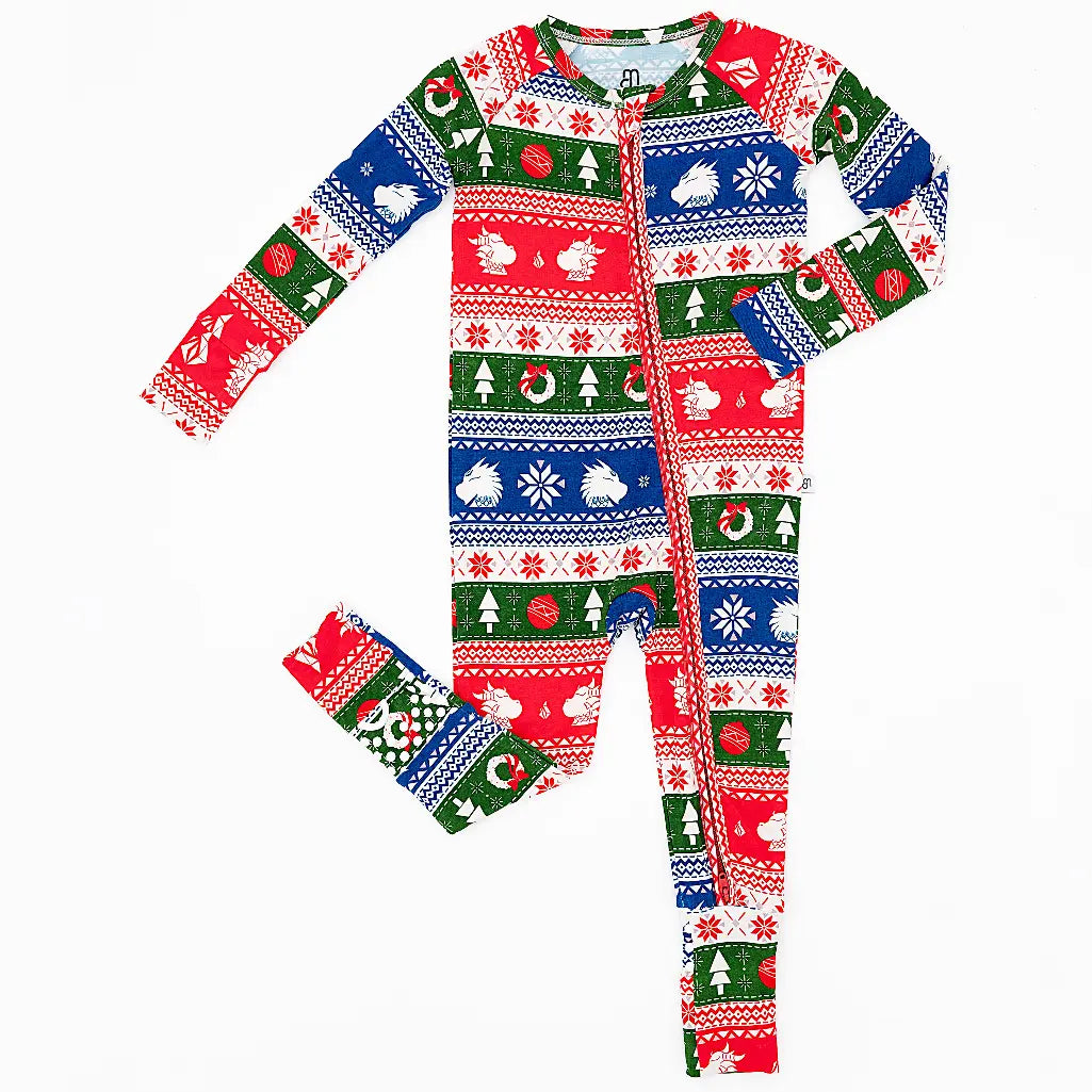 Flat lay of a zip up convertible baby pajama in red, green, blue, and white fair isle stripes with snowflakes, pine trees, and white dragon heads on a white background.