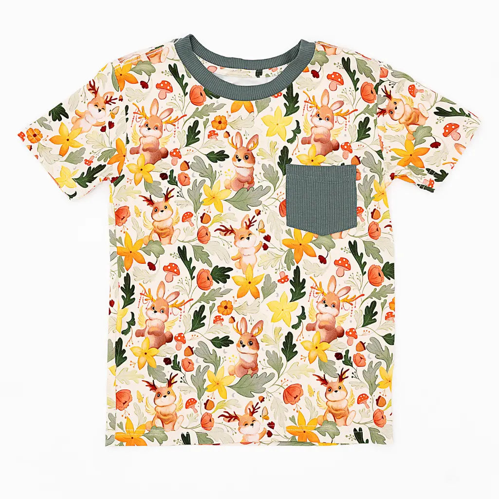A short sleeve pocket tee with a dark green ribbed collar and pocket laid flat on a white background in a woodland jackalope print.