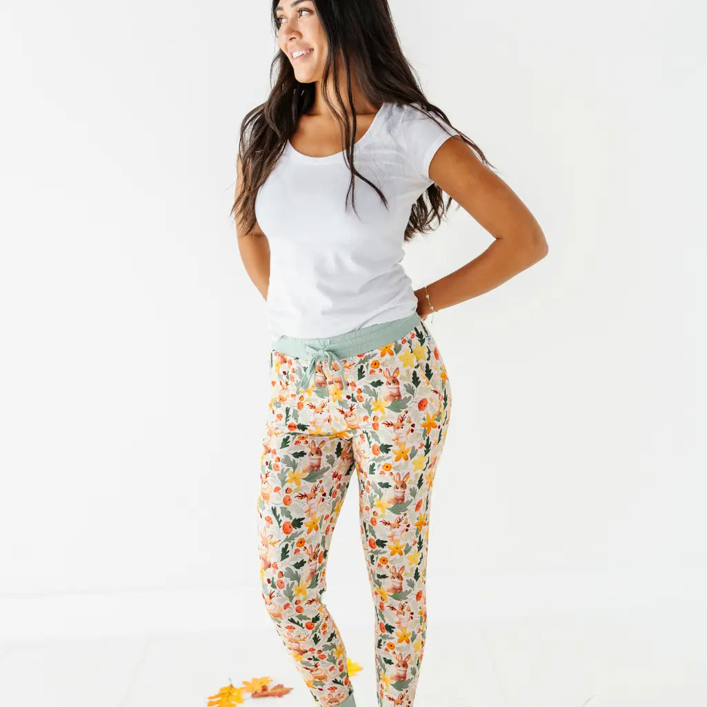 An adult wearing woodland print pajama pants with a sage drawstring waistband and a white tee.