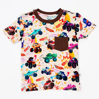 Flat lay of a cream short-sleeve tee with brown trim, a brown chest pocket, and a colorful monster truck print on a white background.