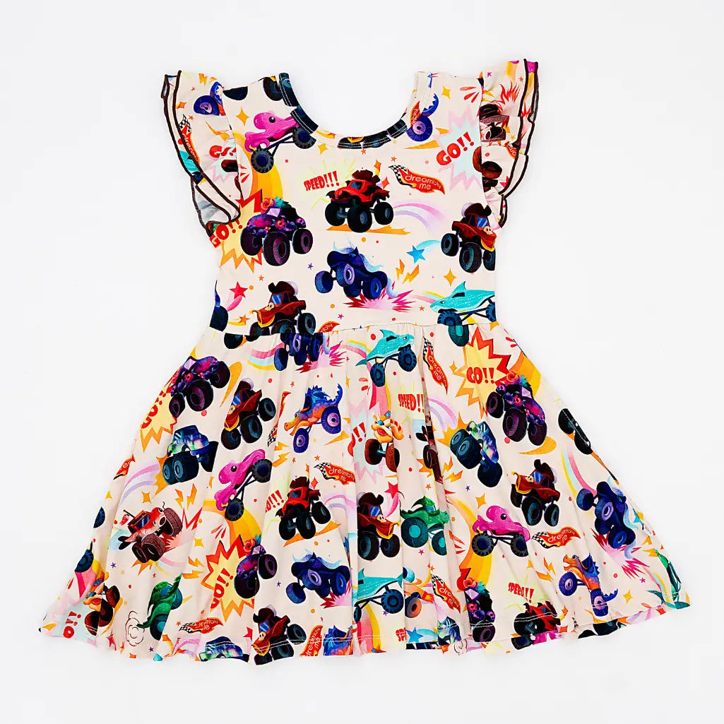 Flat lay of a cream flutter-sleeve twirl dress with a colorful monster truck print on a white background.