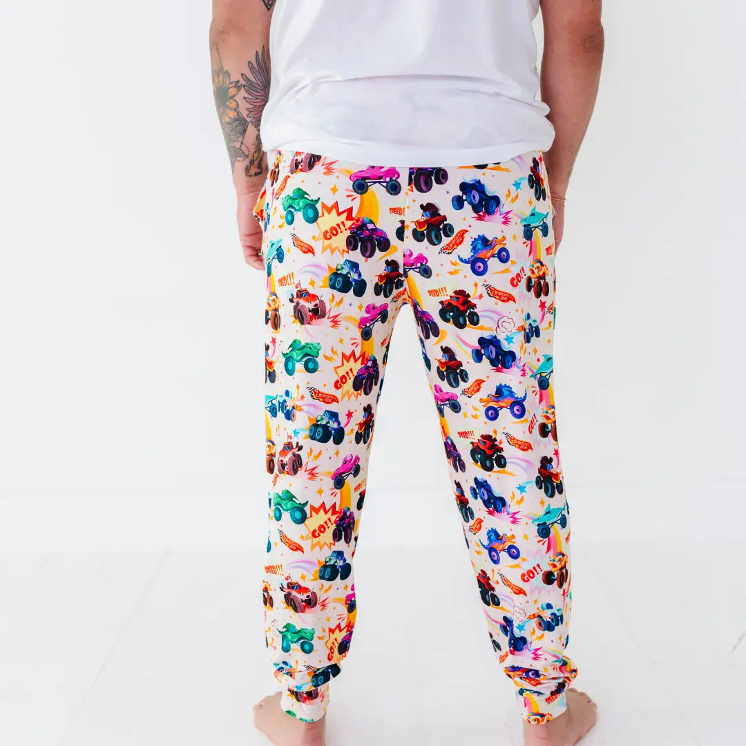 Back view of men's jogger-style pajama pants with a colorful monster truck print.