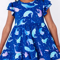 Close up of the front of a flutter sleeve peplum top in a royal blue narwhal print.