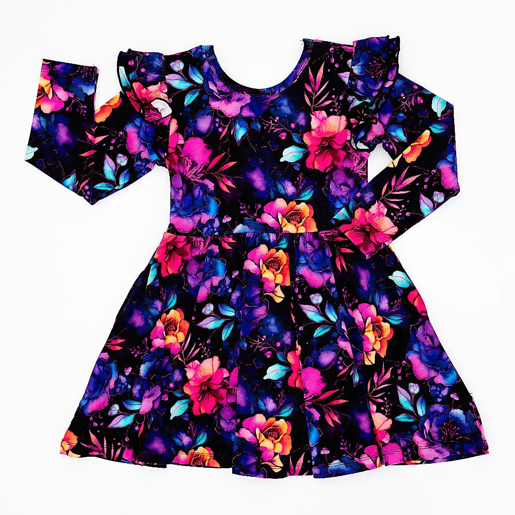 Flat lay of a long sleeve twirl dress with flutter ruffles at the shoulders in a black print of pink, orange, purple, and blue watercolor flowers on a white background.